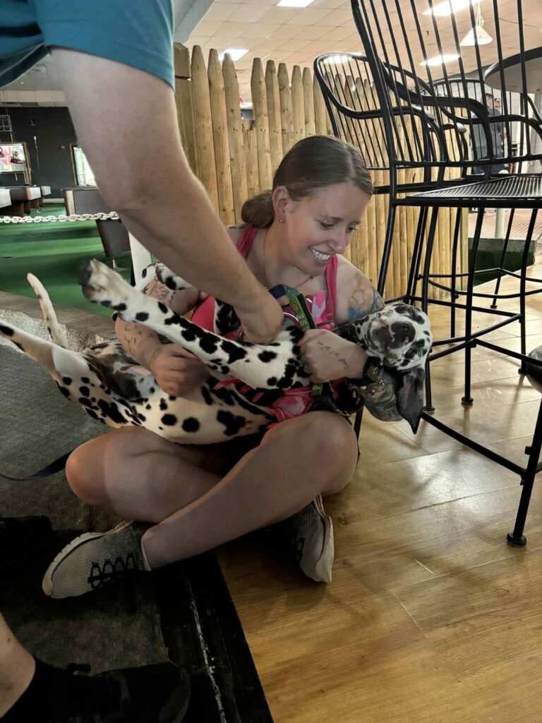 Lindsay sitting on the floor cradling a dalmatian in her lap